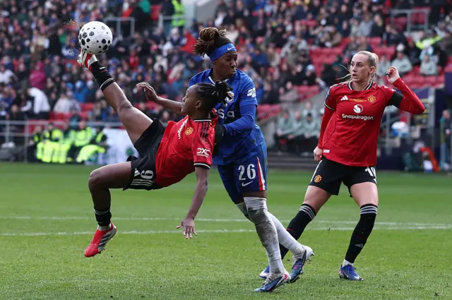 Melvine Malard of Manchester United takes a shot on goal whilst under pressure from Kadeisha Buchanan of Chelsea