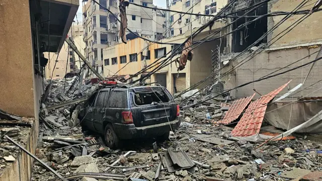 Debris is strewn along a street and vehicles after a residential apartment block was struck in an Israeli airstrike in Beirut's southern suburb of Haret Hreik on 15 March 2026.