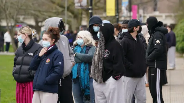 A group of people with blue face masks on.
