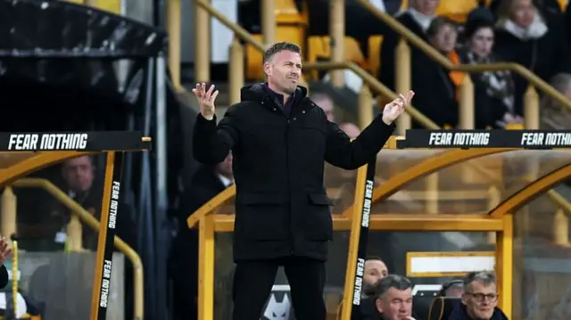 Rob Edwards throws his hands in the air in frustration