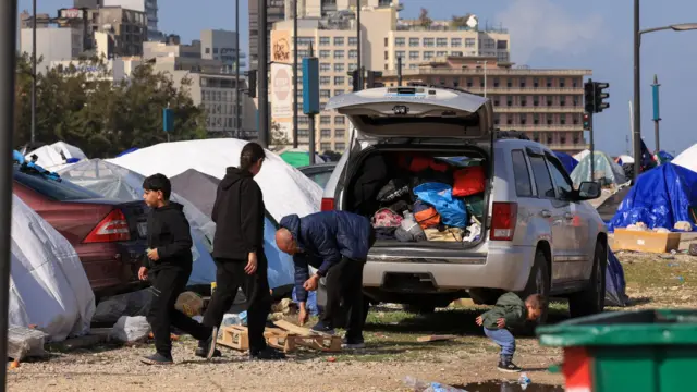 Displaced people outside a car with belongings next to tents, following an escalation between Hezbollah and Israel, amid the U.S.-Israeli conflict with Iran, in Beirut, Lebanon, March 16, 2026.