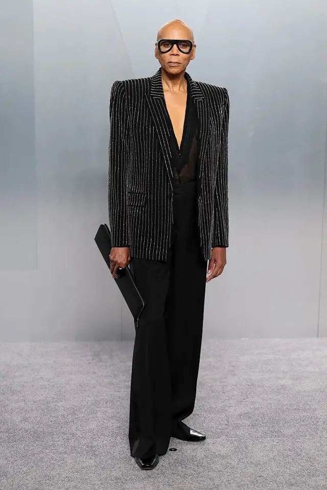 Ru Paul in a pinstripe jacket and black trousers