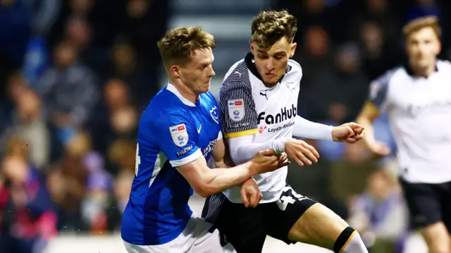 Portsmouth and Derby players challenge for the ball