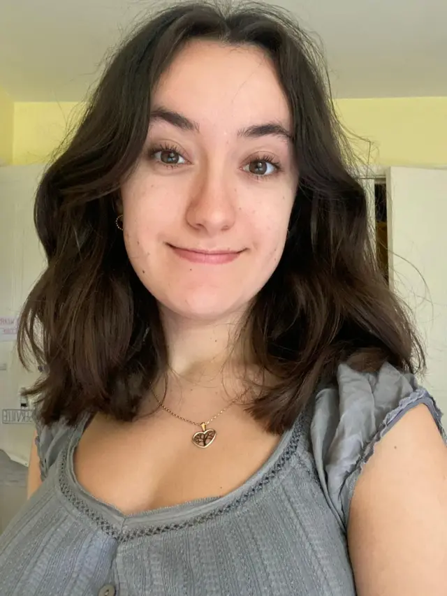 Isabel Kenny is pictured wearing a grey top. She has brown hair.