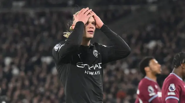 Erling Haaland holds his hands on his head