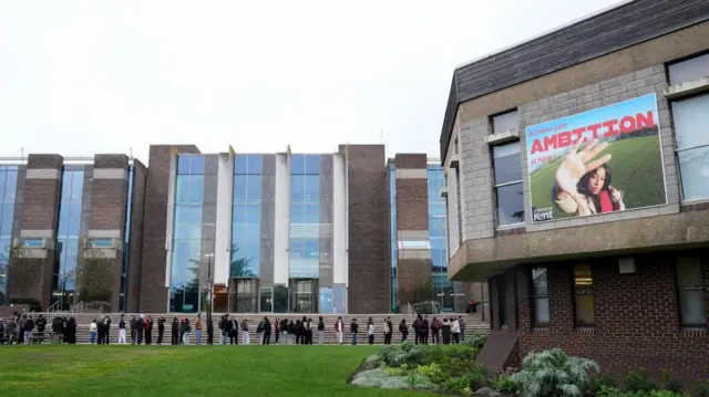 Students queuing for antibiotics outside a building at the University of Kent in Canterbury on Monday