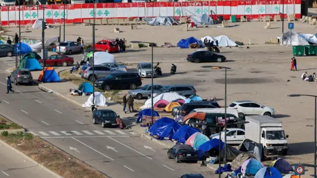 Many tents along a road.