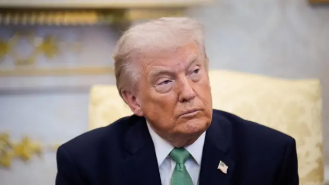 Trump sitting in the Oval Office while people ask questions