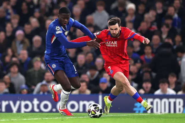Khvicha Kvaratskhelia of Paris Saint-Germain holds off a challenge from Mamdou Sarr
