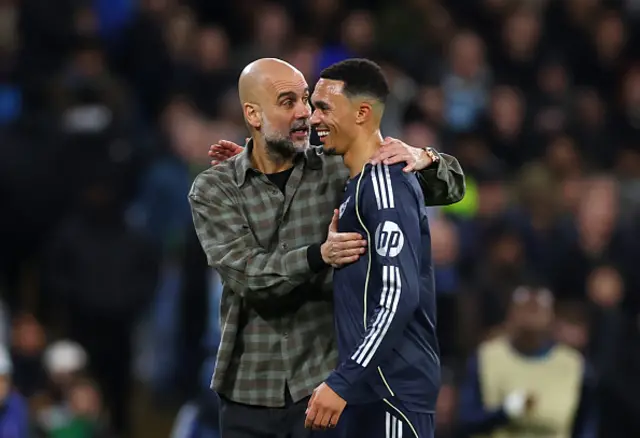Pep Guardiola, head coach of Manchester City speaks with Trent Alexander-Arnold