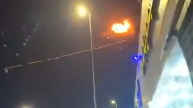 A screengrab from the video showing a line of tracer fire and an explosion