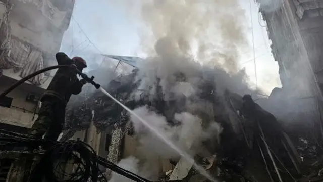 Firefighters at the scene of a missile strike on Beirut's al-Kafaat neighbourhood on 17 March