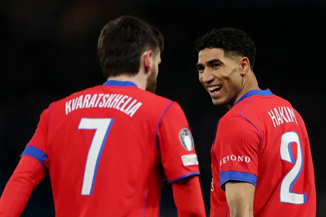 Achraf Hakimi of Paris Saint-Germain smiles in the direction of teammate Khvicha Kvaratskhelia a