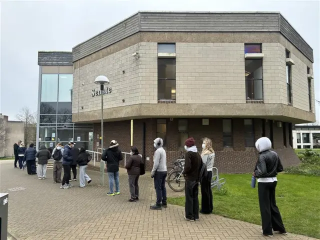 People queue outside the University of Kent building to get antibiotics