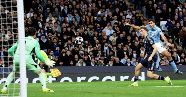 Rodri (R) of Manchester City takes a shot at goal