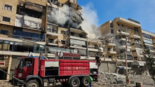 Firefighters work at the site of an Israeli airstrike in the southern suburbs of Beirut on March 17, 2026