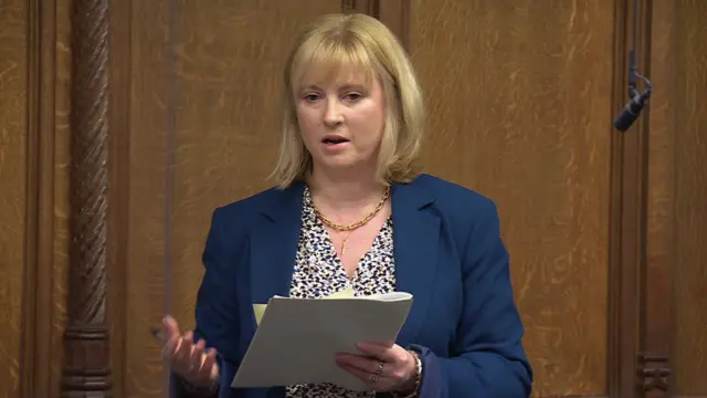 Rosie Duffield MP speaking in House of Commons, reading off sheets of paper and gesturing with the right hand