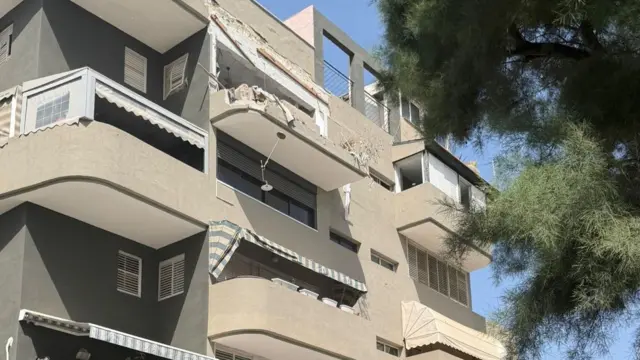 A view of the buildings facade, showing a blown-out apartment