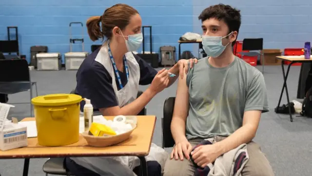 22-year-old postgraduate law student Oliver Contreras receives an injection in the sports hall at University of Kent campus in Canterbury, where the rollout of a meningitis B vaccine to about 5,000 students has begun