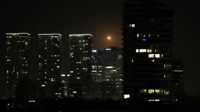 Streaks of fire and light cross the night sky as an Israeli interceptor strikes an Iranian missile amid the U.S.-Israeli conflict with Iran, over Tel Aviv