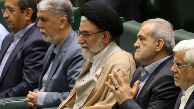 Iran's then-Minister of Intelligence Esmail Khatib (C) sits with Iran's then-President Masoud Pezeshkian (C-R) before a speech to members of parliament in the capital Tehran, on August 17, 2024
