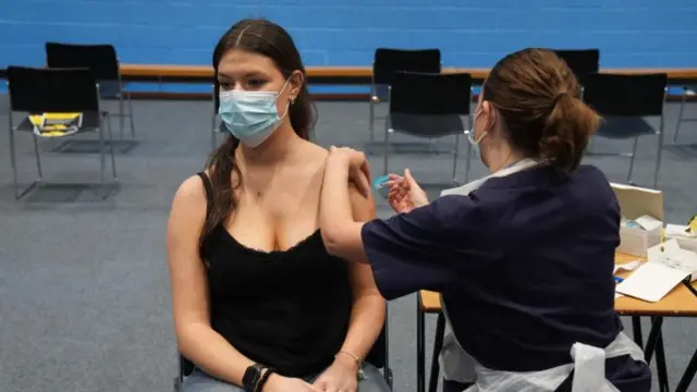 A girl receives a jab in a sports centre