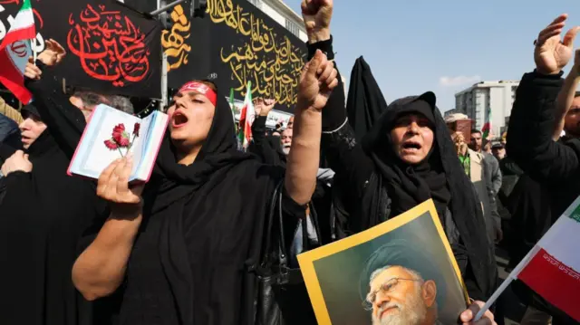Women chant slogans during the funeral of Iranian security chief Ali Larijani and victims of the IRIS Dena warship at Enghelab Square