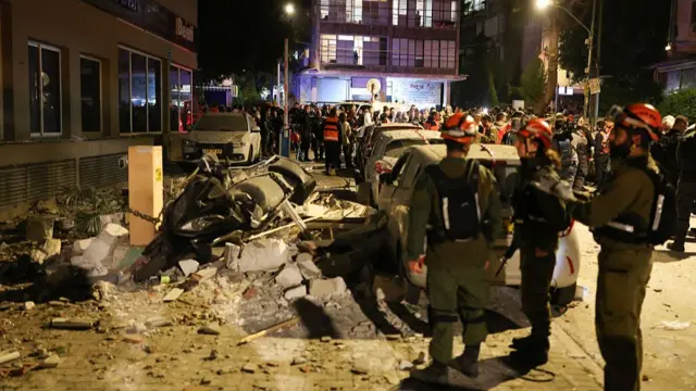 Emergency services respond to damage from an Iranian missile strike in Ramat Gan