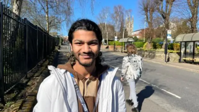 Mohammed Sheik stands in street smiling at the camera