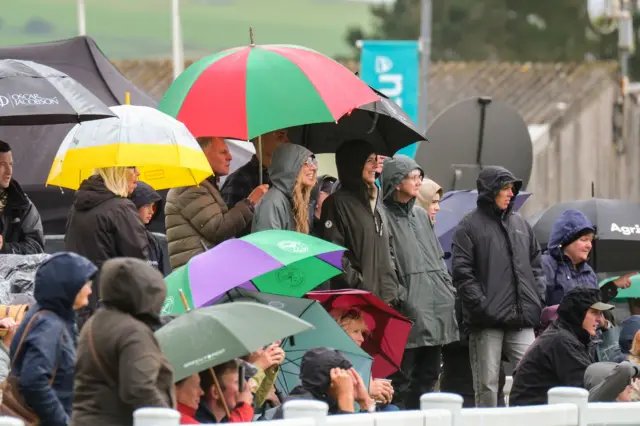 People stand under umbrellas at the Royal Cornwall Show