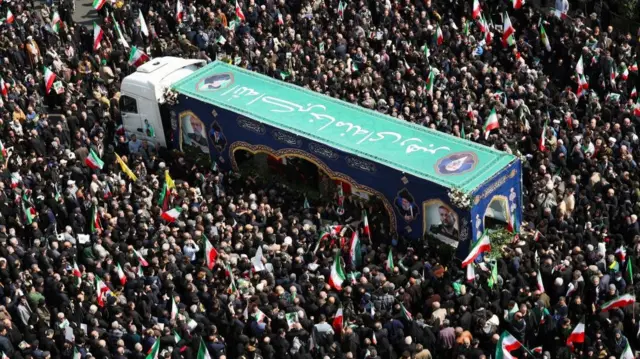 People gather around the coffin of Iranian security chief Ali Larijani during a funeral for Larijani and victims of the IRIS Dena warship at Enghelab Square, amid the U.S.-Israeli conflict with Iran, in Tehran, Iran, March 18, 2026.