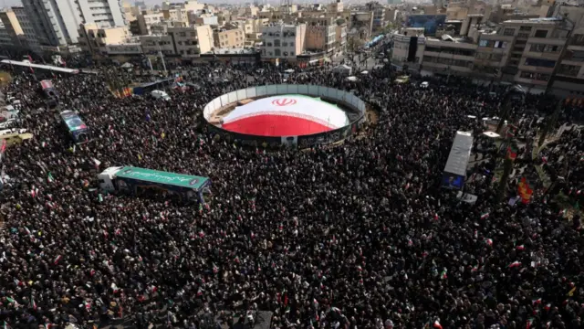 Trucks carrying coffins draped in Iranian flags moved through the procession in Enghelab Square