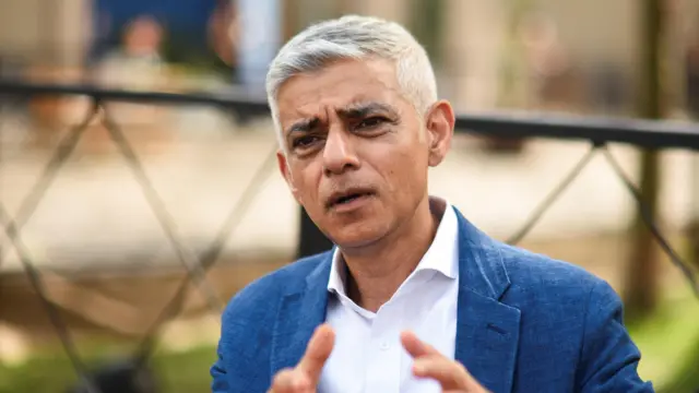 Sadiq Khan wearing a white shirt and a blue jacket
