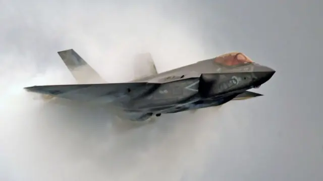 A US F-35 C emerges from smoke at a display during the Pacific Air Show