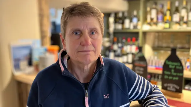 Cathy Sanders, who runs the Tradesman's Arms in Stokenham, sits on a chair next to the bar