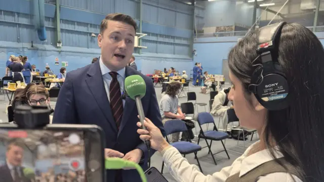 Wes Streeting speaks to BBC Newsbeat's Pria Rai at a sports hall at the University of Kent