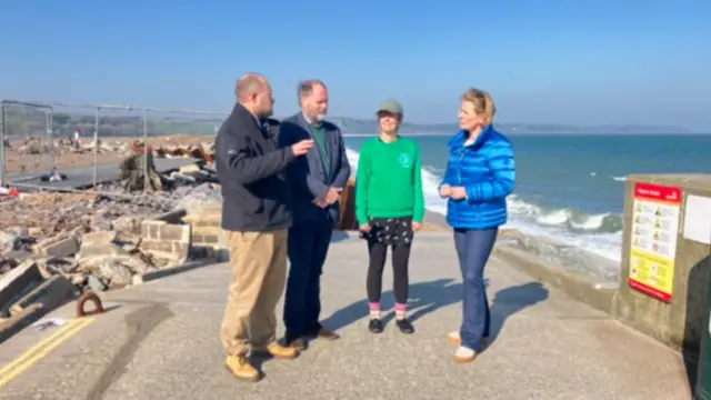 Three people stood together being interviewed by Victoria Graham.