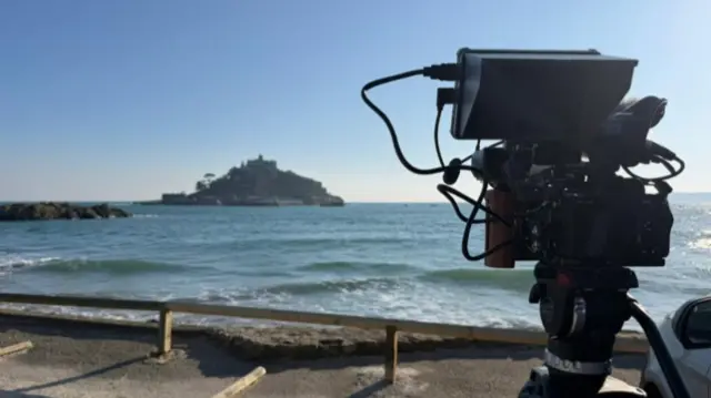 St Michael's Mount in the distance with a camera on the right.