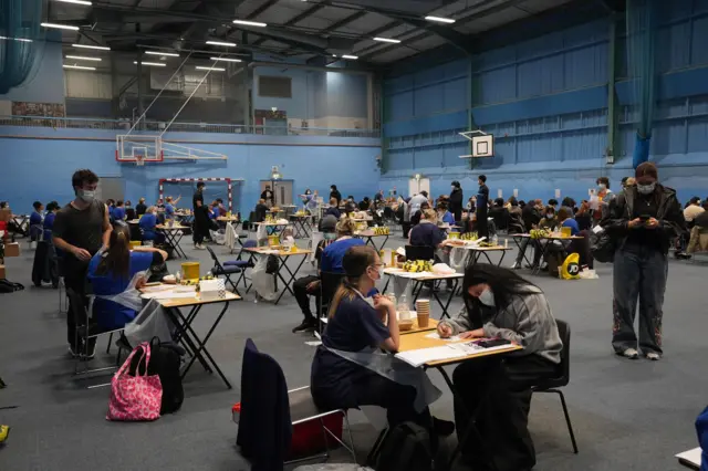 Students receiving vaccines and antibiotics from medical staff in the sports hall