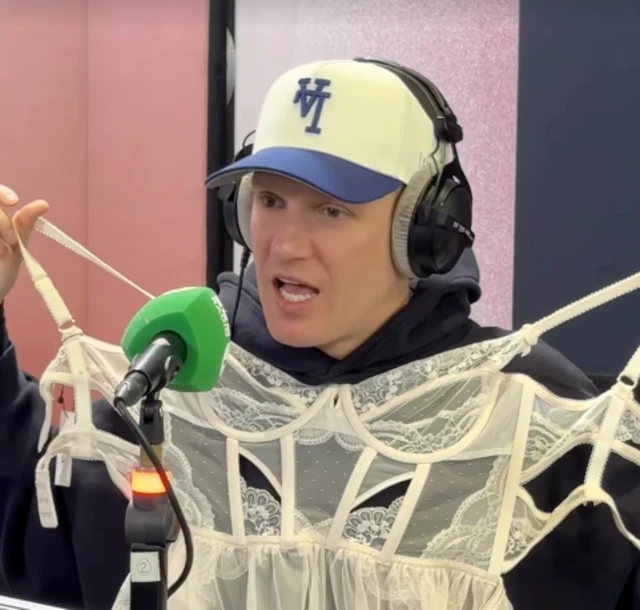Jamie Laing holds up the white lingerie he'll be forced to wear if Radio 1 listeners raise another £150k by 9.30am