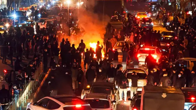 A protest in Tehran in January, people gather near a fire
