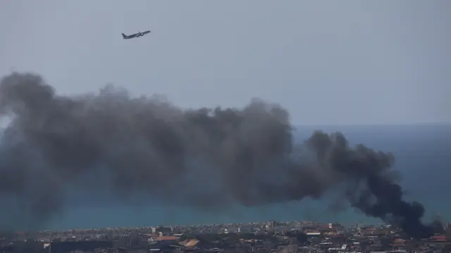 An aircraft of Middle East Airlines, Lebanon's national carrier, taking off from Beirut International Airport as smoke billows following Israeli airstrikes.