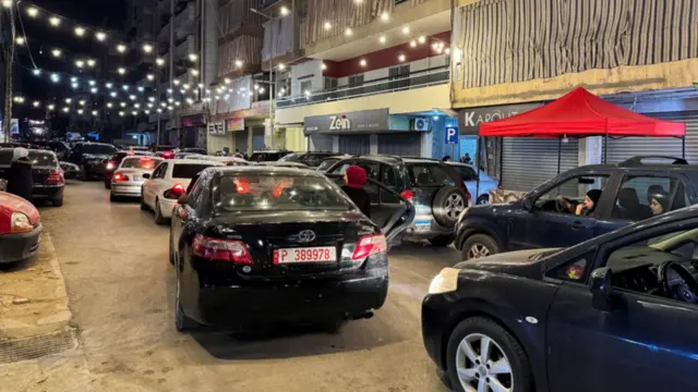 A queue of cars on a brightly lit street in Beirut