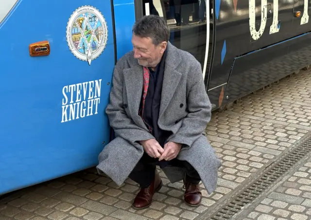 Steven Knight crouching next to his name
