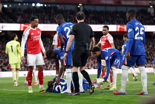 Andrey Santos of Chelsea pulls Joao Pedro of Chelsea back on the pitch after he lies injured during the Premier League match between Arsenal and Chelsea at Emirates Stadium on March 01, 2026.