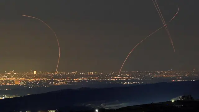 An Iranian missile flies towards Israel as Israeli air defence operates, amid the U.S.-Israeli conflict with Iran, as seen from Hebron, in the Israeli-occupied West Bank