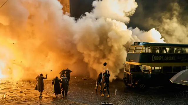 A still from the film showing an explosion with people running