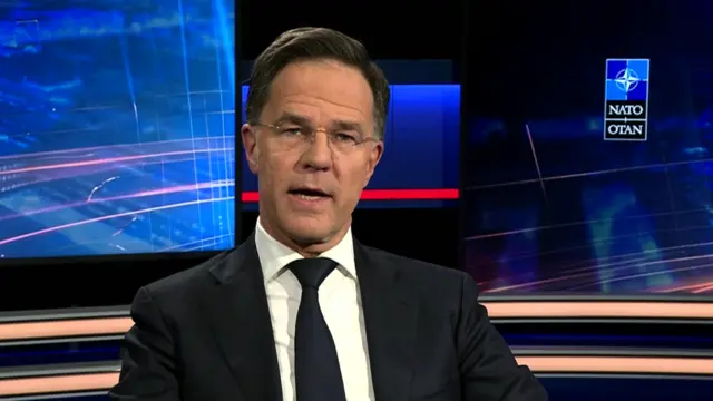 Nato secretary general sitting down in a dark suit and tie during an interview in a studio inside Nato headquarters