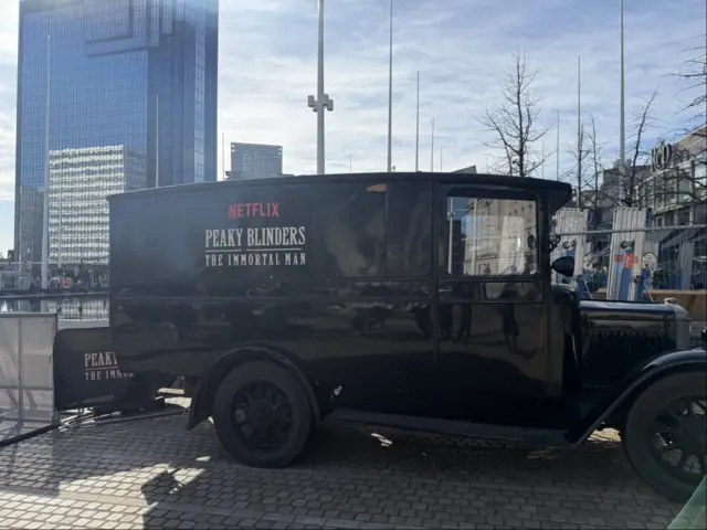 A brown vintage van with Peaky Blinders, The Immortal Man written on the side