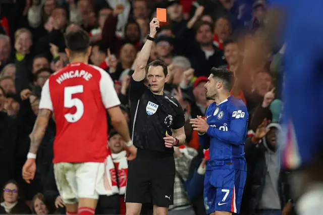 Referee Darren England (C) issues a red card to Chelsea's Portuguese midfielder #07 Pedro Neto (R) after his second yellow, during the English Premier League football match between Arsenal and Chelsea at the Emirates Stadium in London on March 1, 2026.